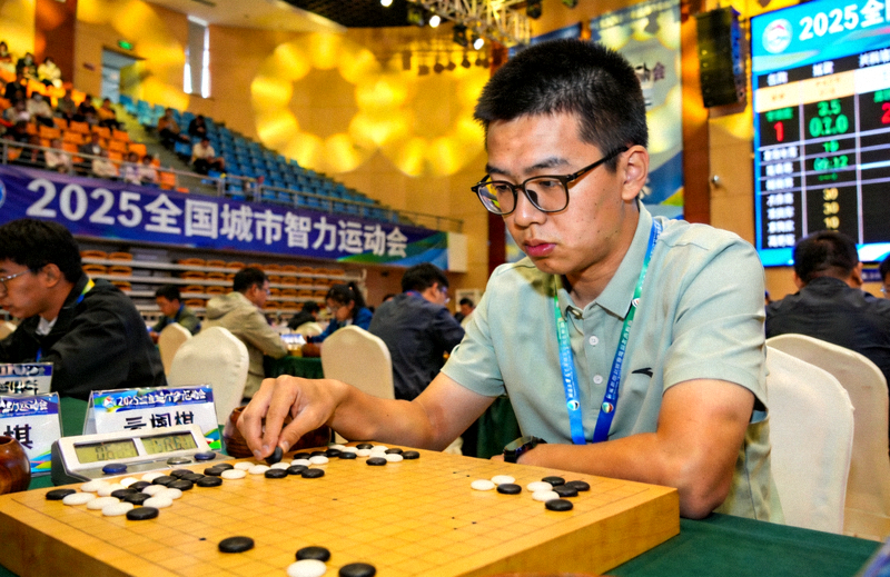 2025 全国城市智力运动会现场，参赛选手在围棋棋盘前专注对弈，赛场氛围庄重而热烈